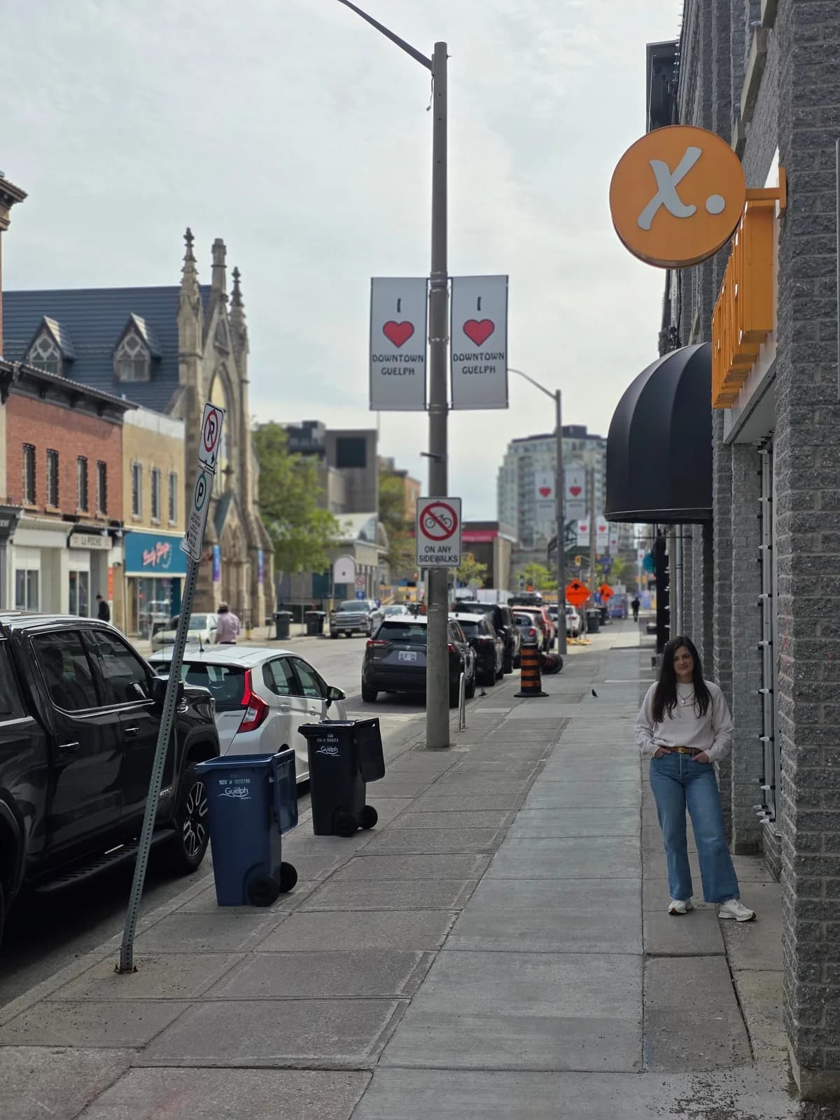 Jon's wife on a downtown Guelph sidewalk outside The Ten Spot, with Downtown Guelph street banners and historic storefronts behind her.