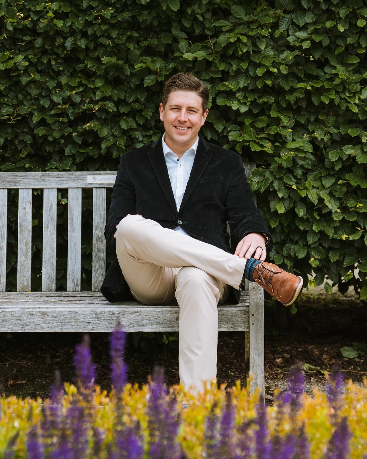 Jon Christensen seated on a garden bench in Guelph