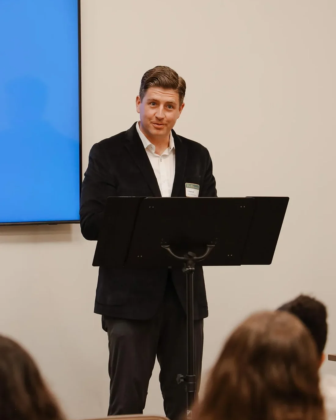 Jon Christensen speaking at a podium at a community meeting